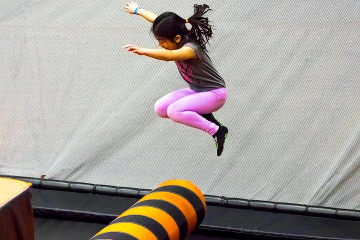 una niña saltando de un trampolín