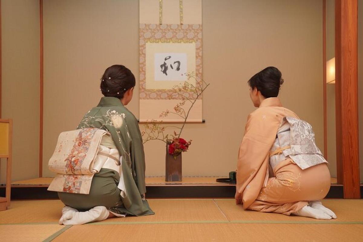 duas mulheres sentadas no chão olhando para uma pintura