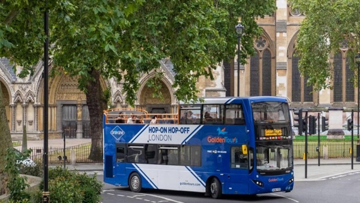 Egy kék emeletes busz parkolt egy épület előtt
