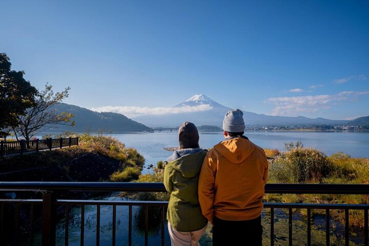 two people standing on a balcony looking at a mountain