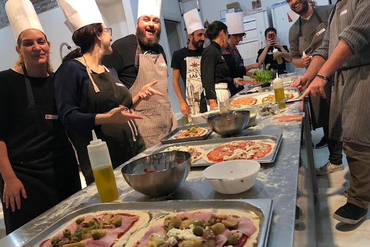 a group of people standing around a table with pizzas