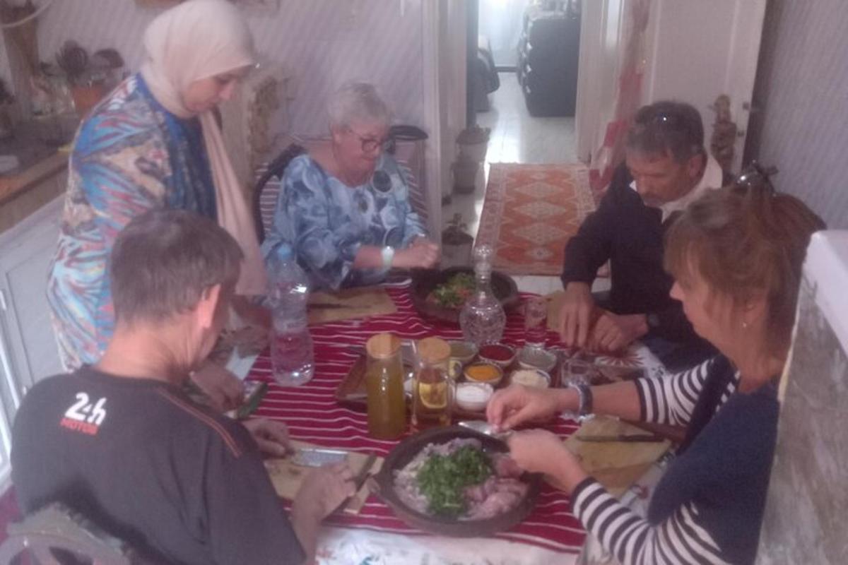 hópur fólks situr við borð og borðar mat
