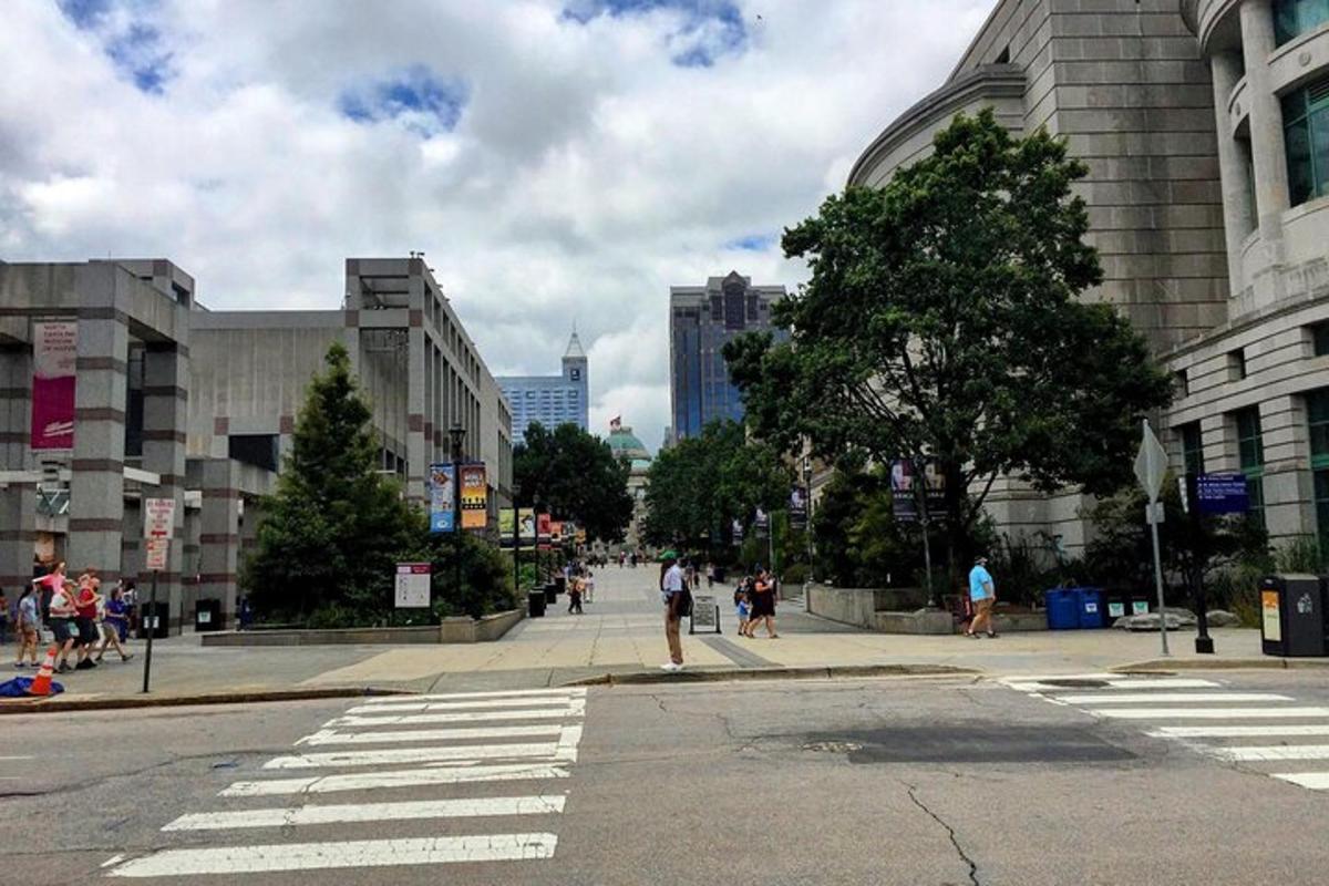 a city street with people walking on a crosswalk