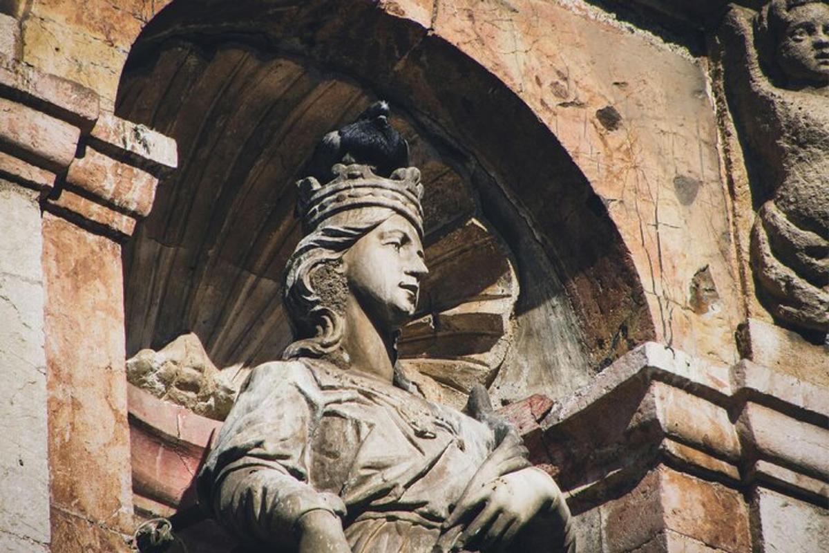 una estatua sentada al costado de un edificio