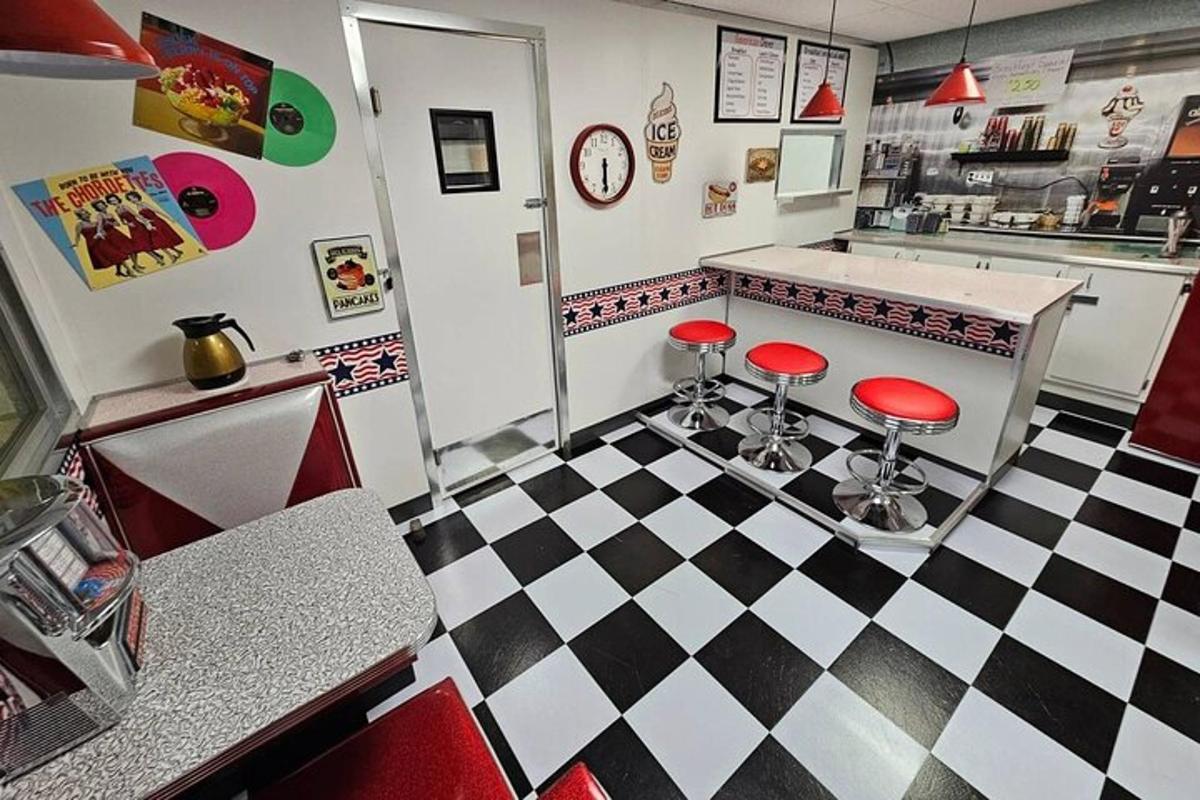 restaurace s červenými stoličkami na kostkované podlaze