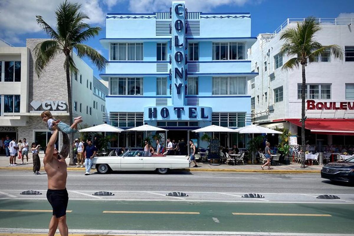 um homem segurando um bebê em frente a um hotel