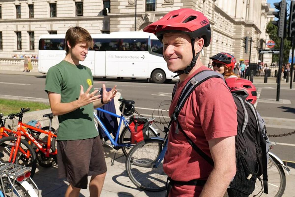 due uomini sono in piedi su una strada con le biciclette