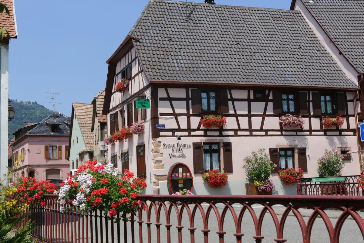 a building with flowers in front of a fence