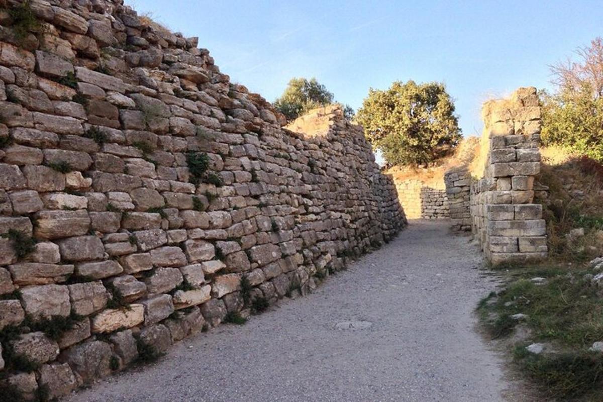 ένας μεγάλος πέτρινος τοίχος με ένα μονοπάτι δίπλα του