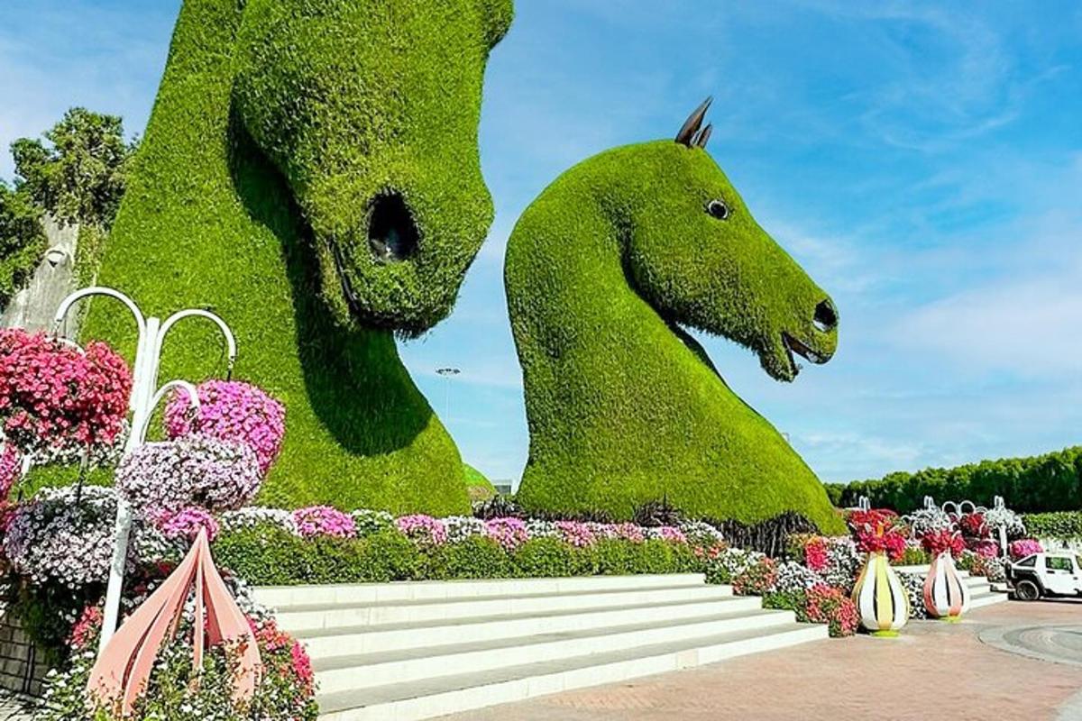 eine Ausstellung grüner Pferde in einem Garten mit Blumen