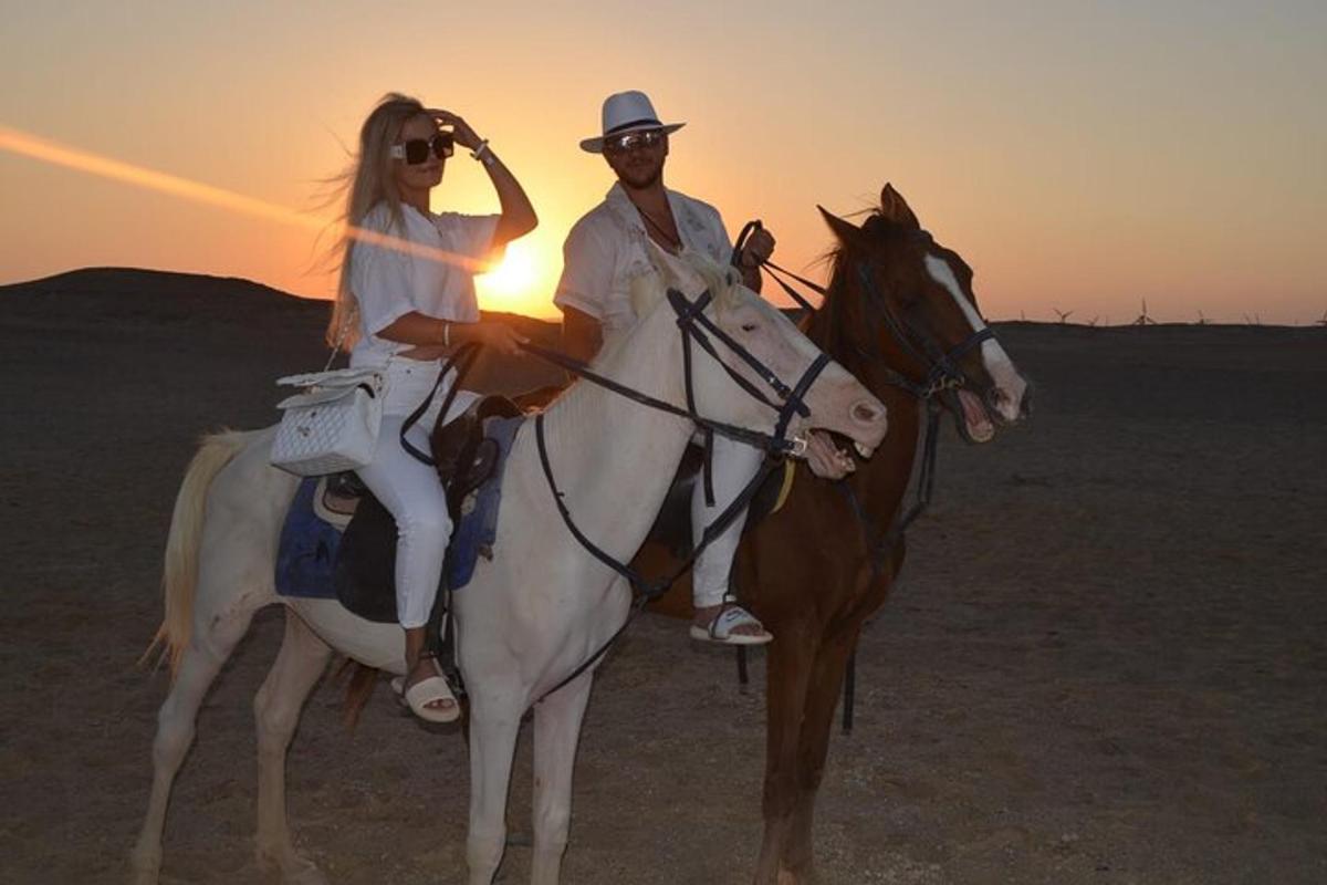 um homem e uma mulher cavalgando no deserto