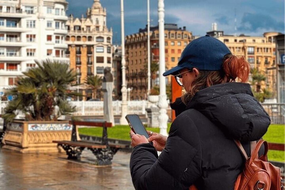 žena se dívá na svůj mobilní telefon v dešti
