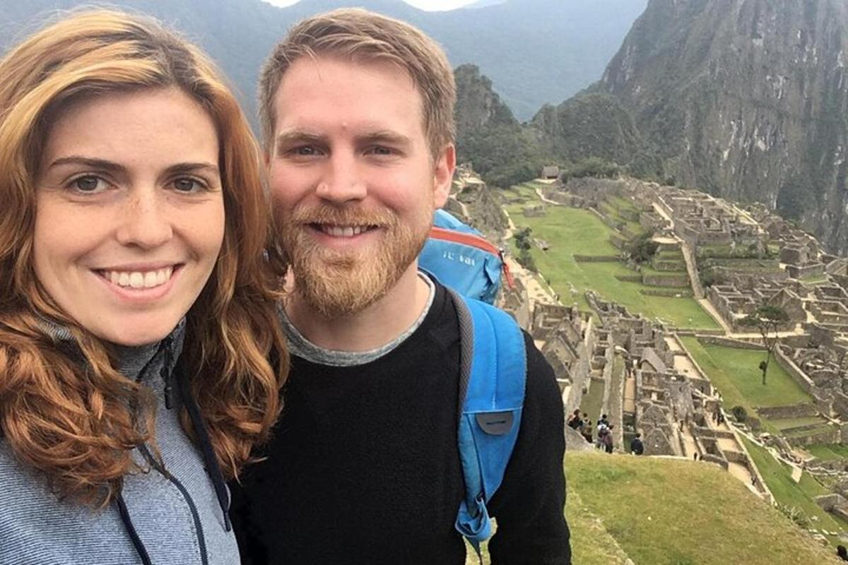 un uomo e una donna in piedi sulla cima di una montagna