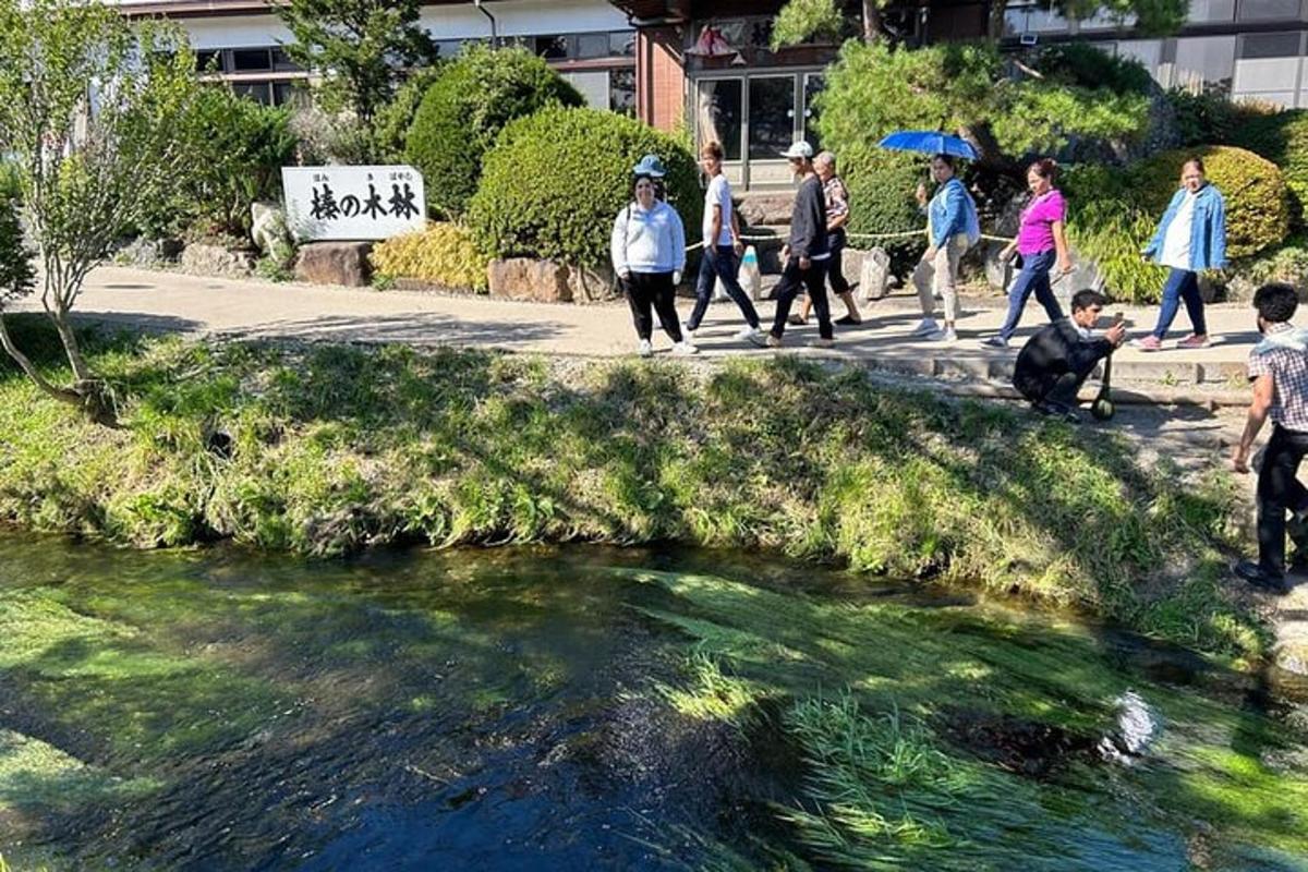 sekumpulan orang berjalan di kaki lima di sebelah sungai