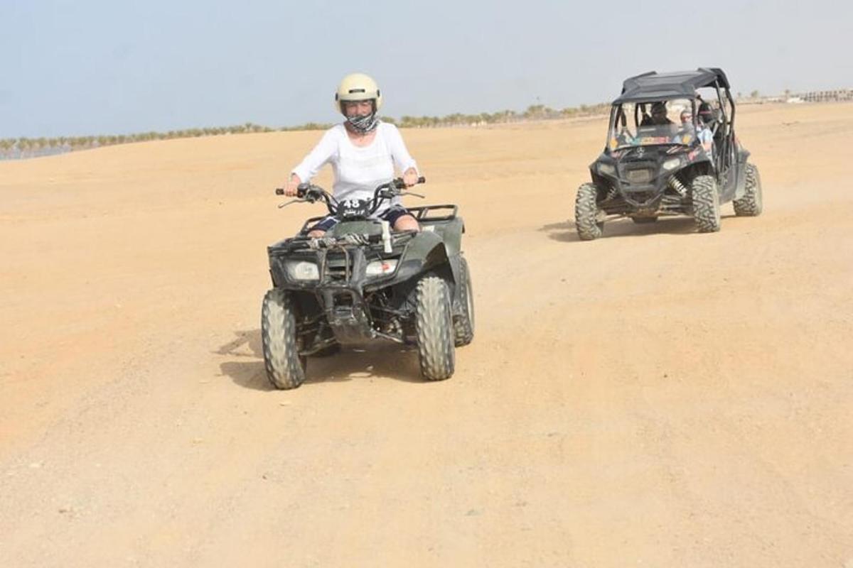 Dos personas en vehículos todo terreno y un jeep en el desierto