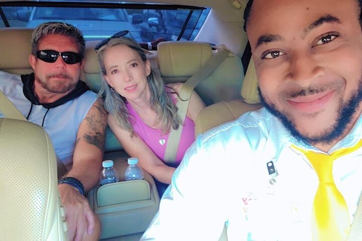 um grupo de três pessoas sentadas em um carro