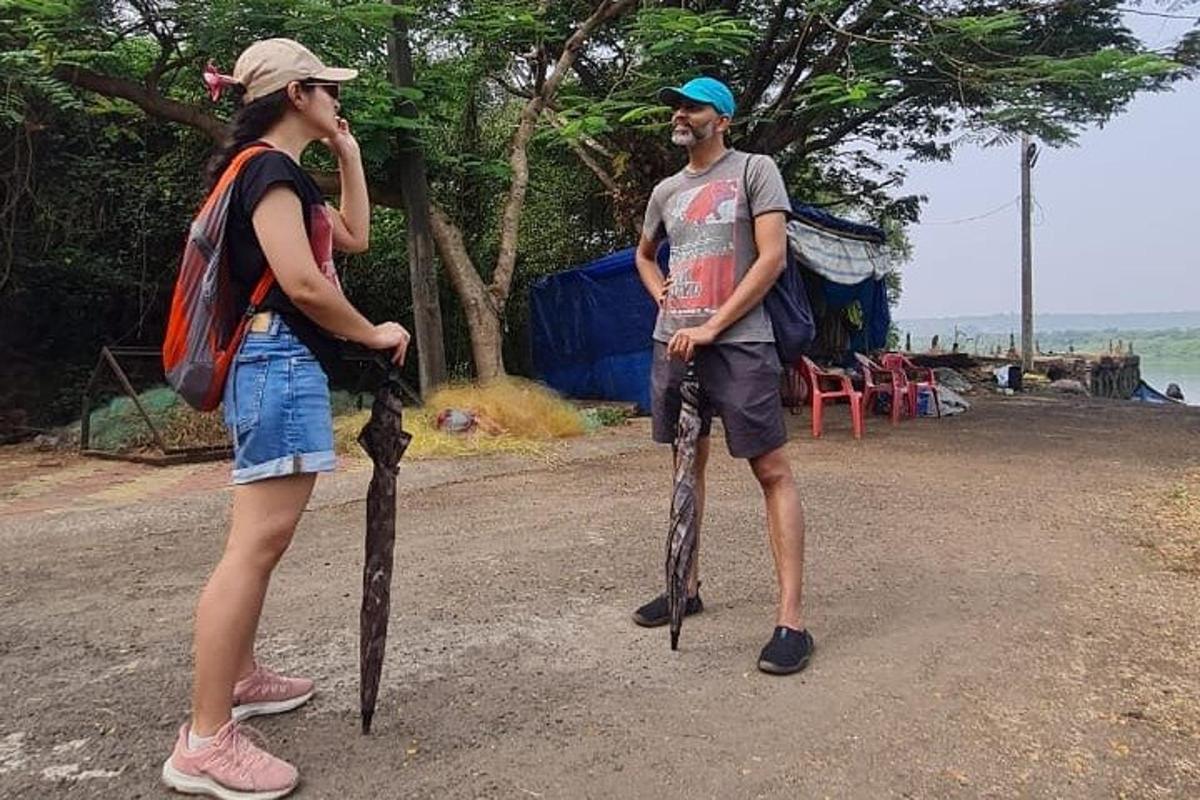 seorang lelaki dan seorang wanita berdiri di atas jalan dengan payung