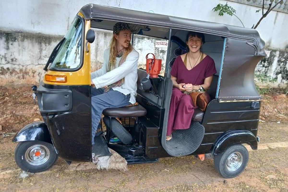 two women sitting in the back of a small vehicle