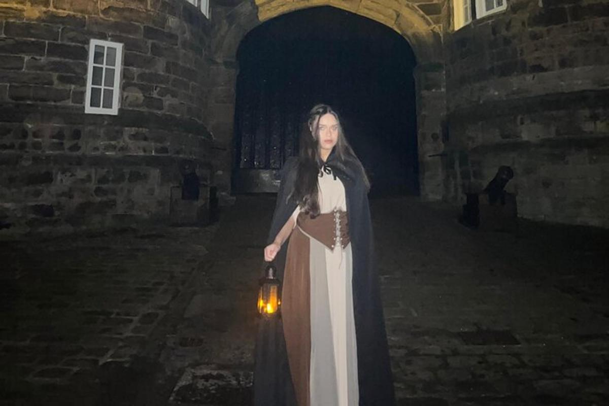 a woman in a dress standing in a castle