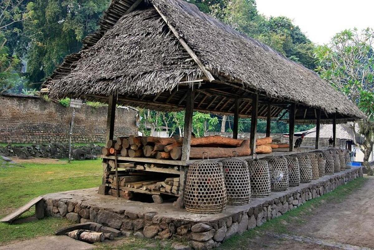 sebuah bangunan dengan bumbung jerami dengan kayu balak dan bakul
