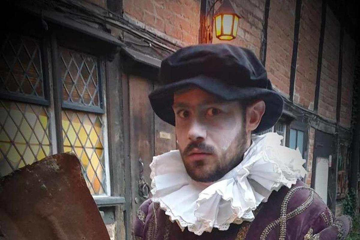 a man with a mask on his face standing in front of a building