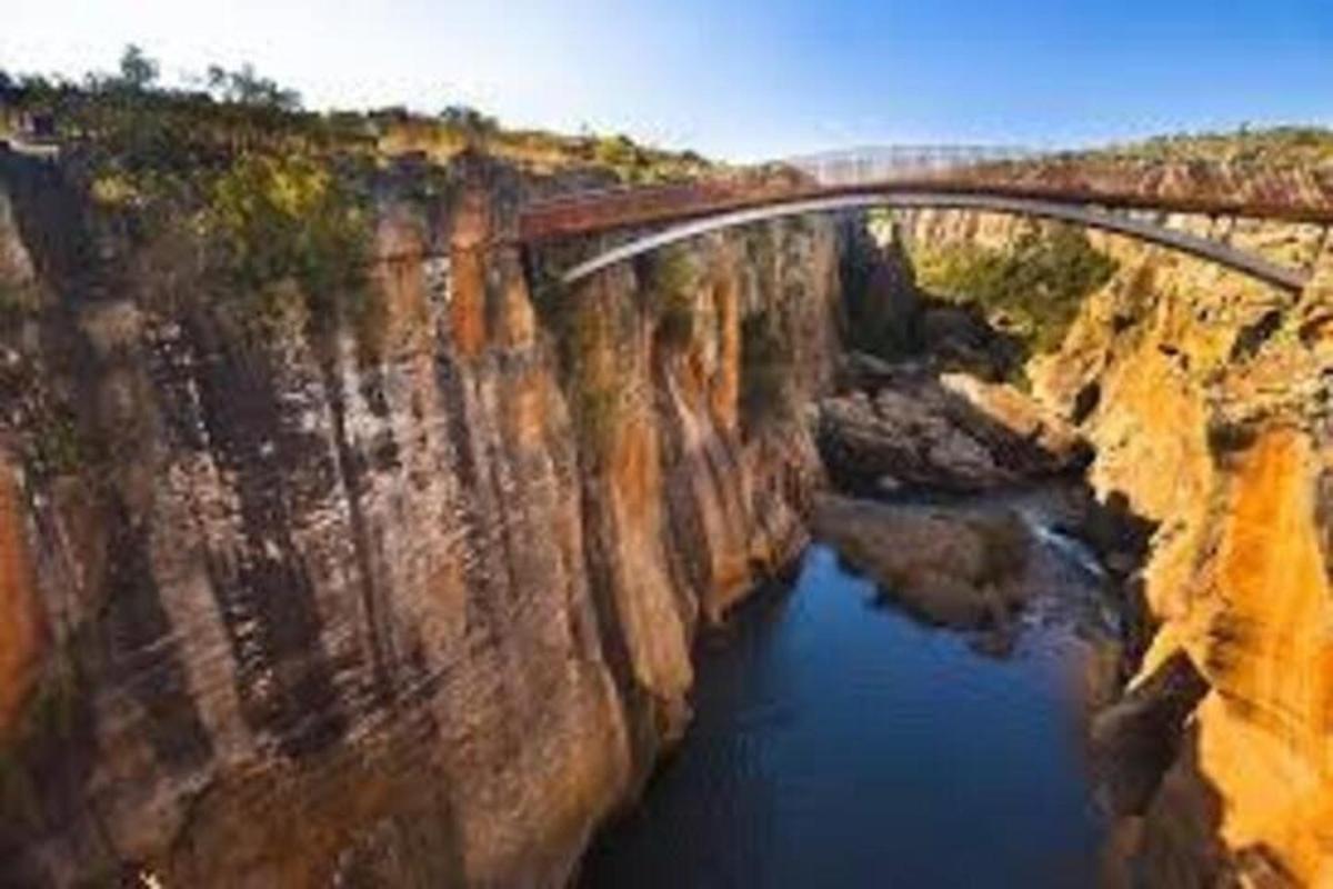 a bridge over a river on top of a cliff