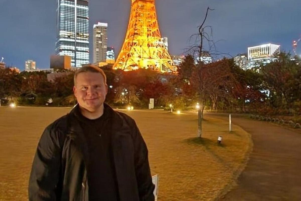muž stojící před Eiffelovou věží