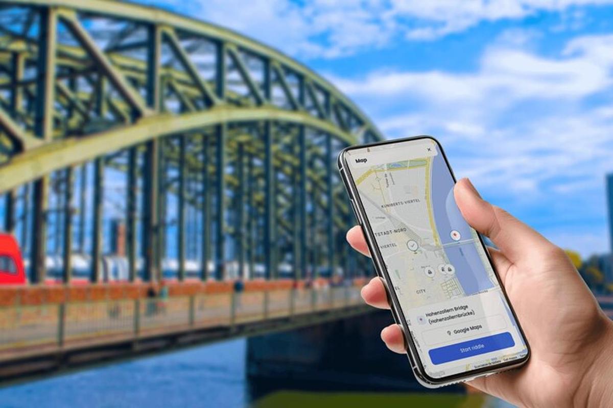 a person holding a cell phone in front of a bridge