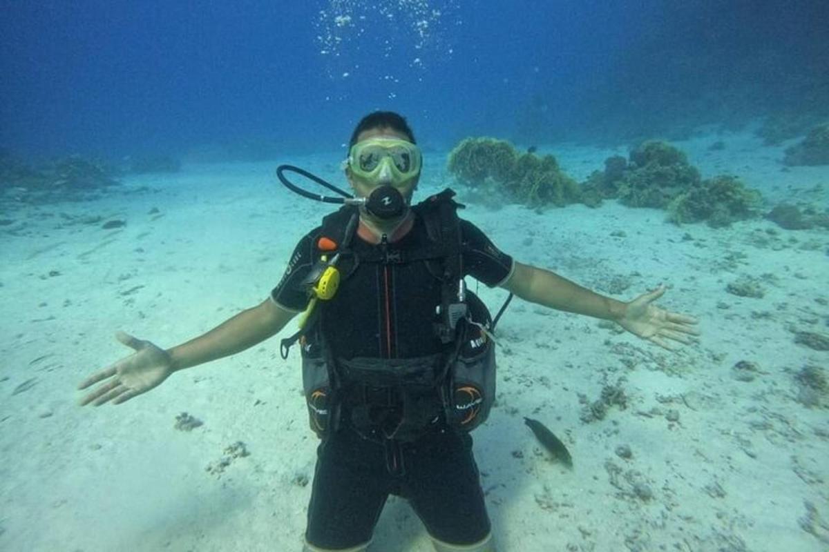 isang lalaking nakasuot ng diver suit na nakatayo sa karagatan