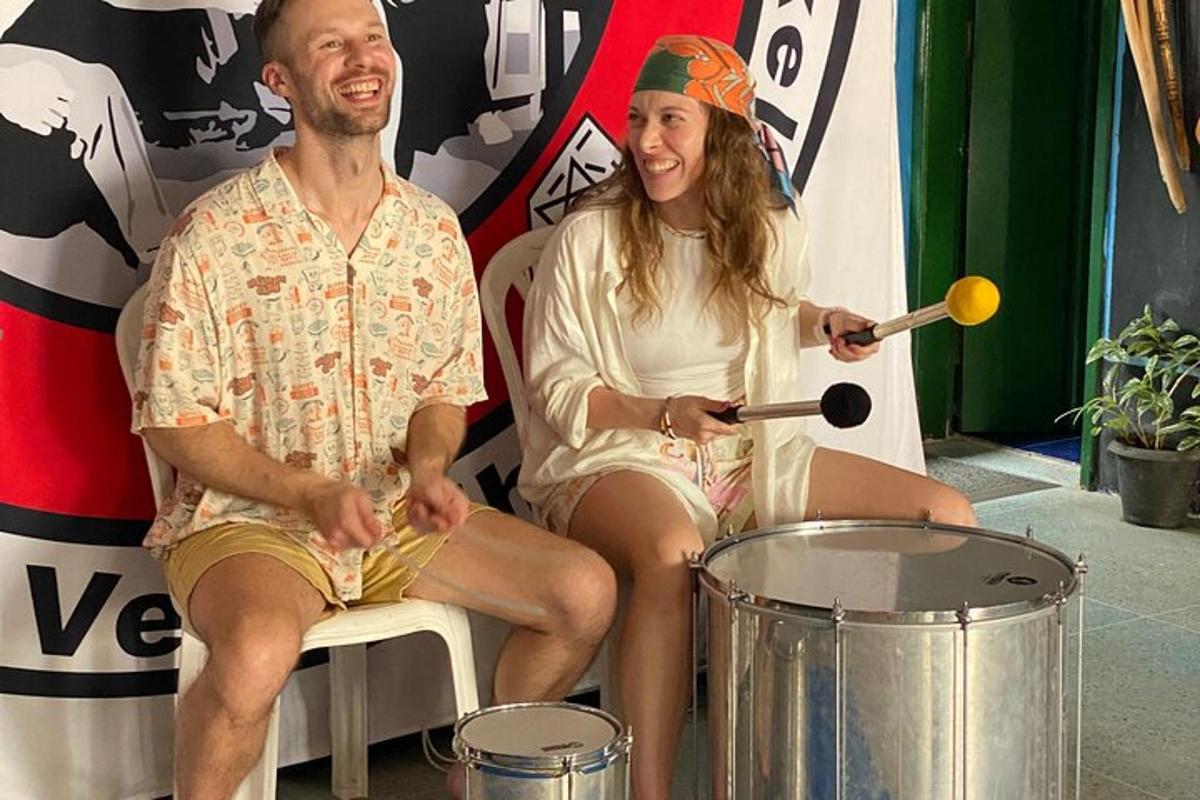 a man and woman sitting next to a drum