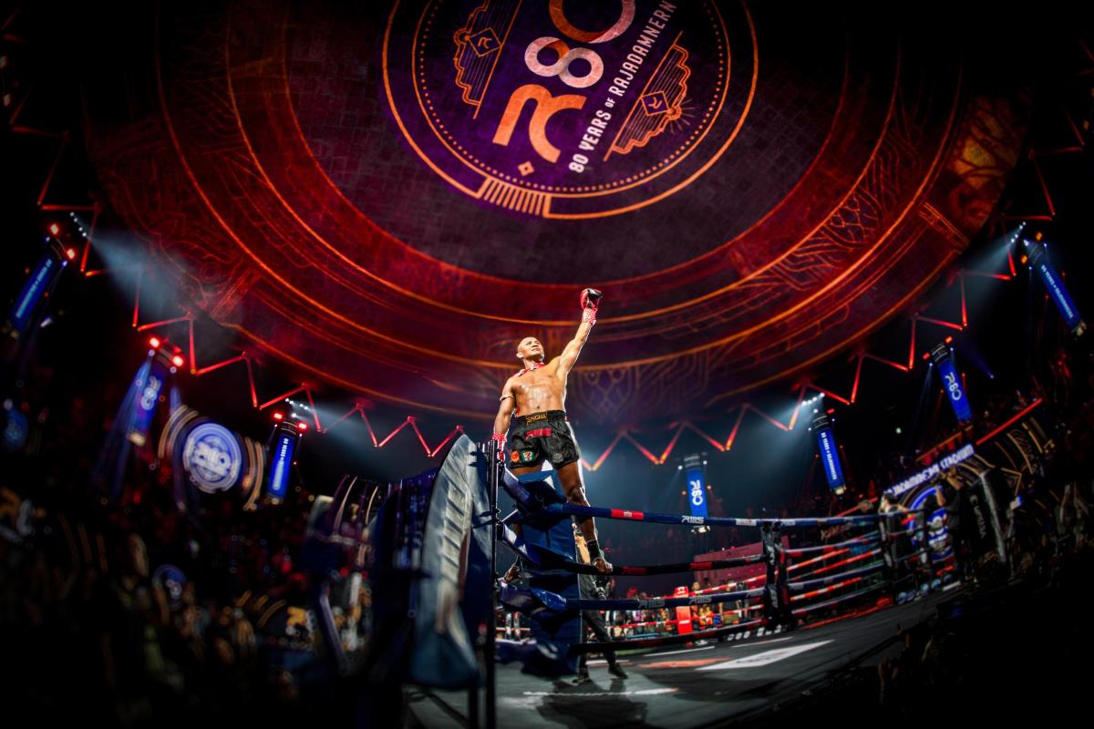 a man standing in the middle of a boxing ring
