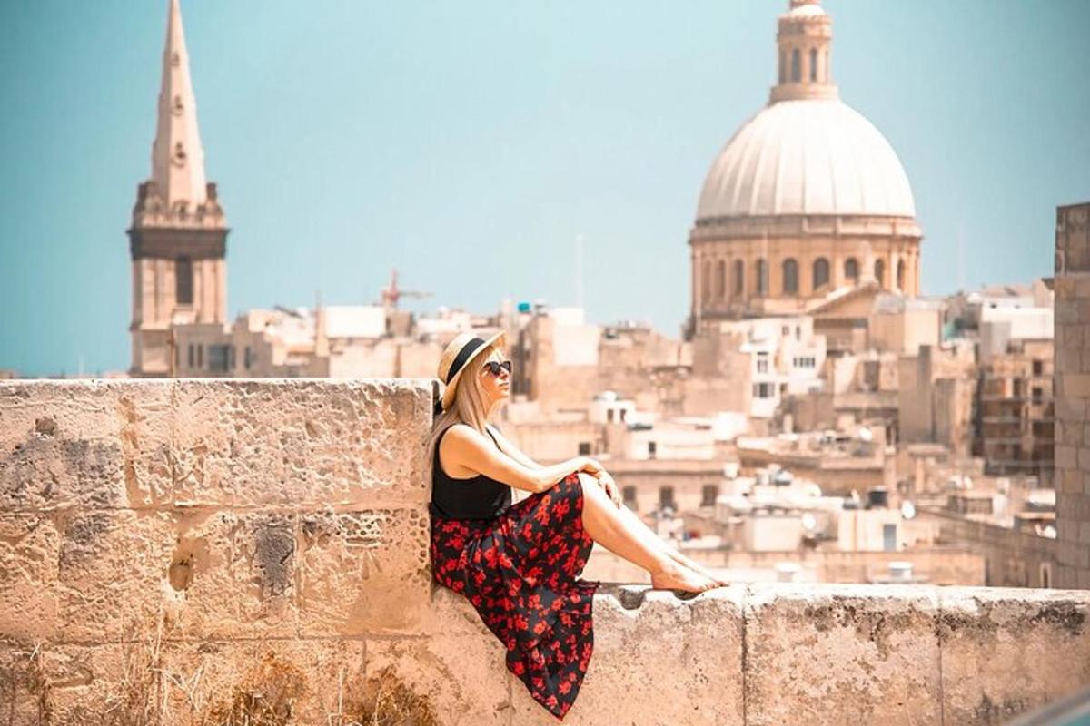 a woman sitting on a wall with a view of a city
