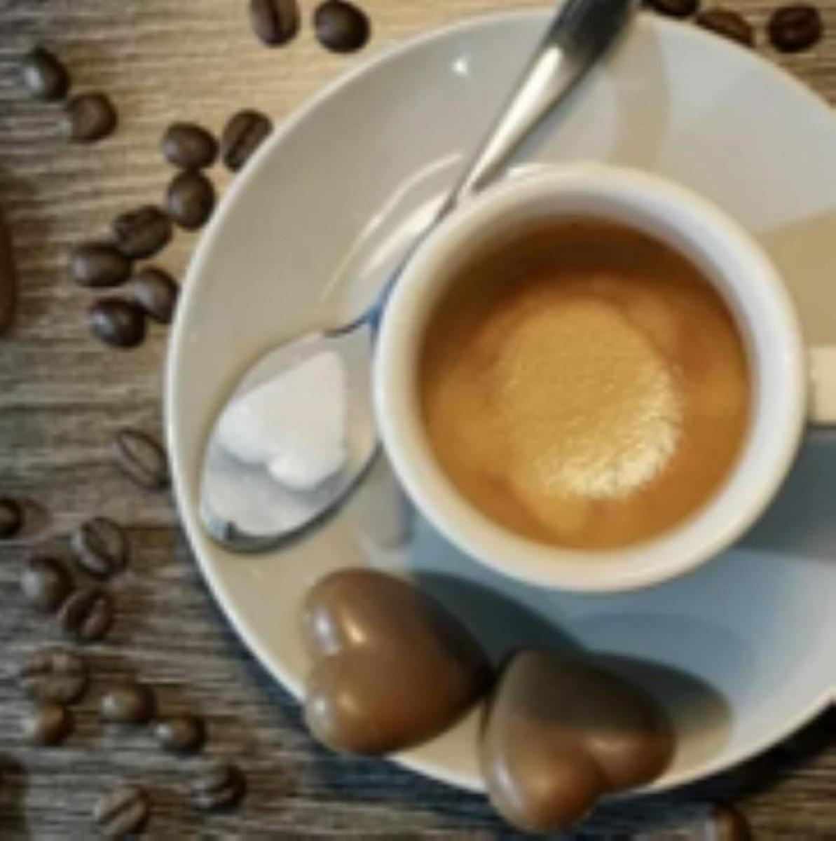 a cup of coffee on a plate with coffee beans