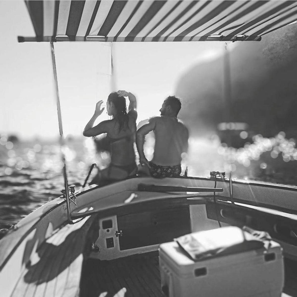 un uomo e una donna seduti sul retro di una barca