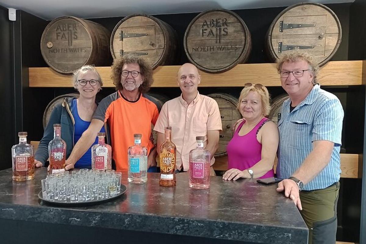 a group of people standing behind a bar with bottles of whiskey