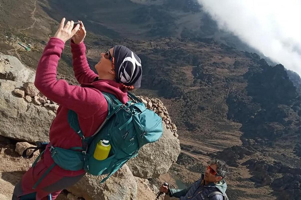 una donna in piedi sul fianco di una montagna