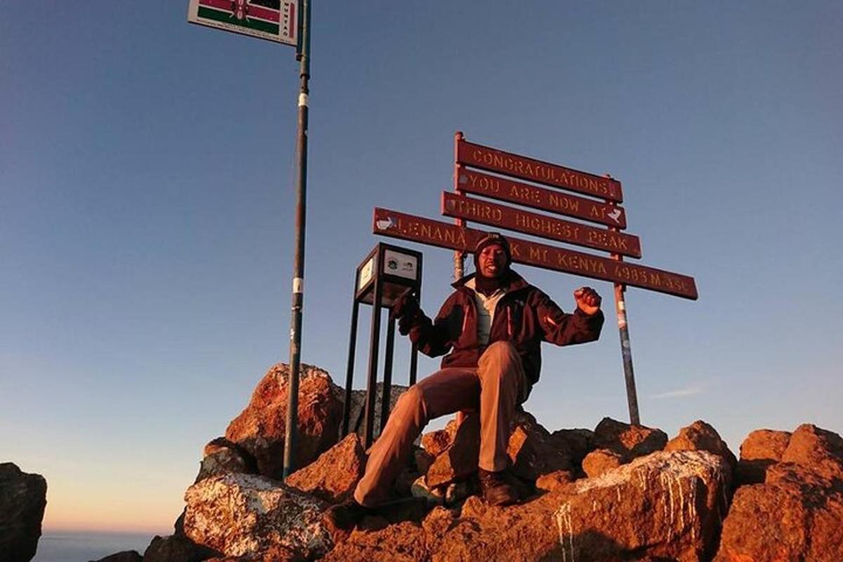 un uomo seduto in cima a una montagna con dei cartelli