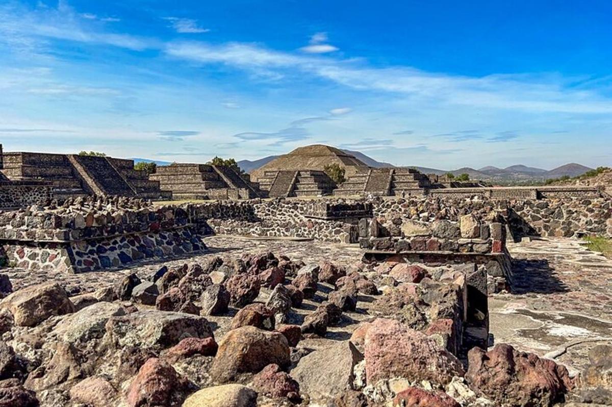 an ancient amphitheater with rocks and mountains in the background