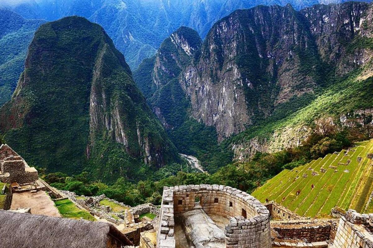 una vista di una catena montuosa con un edificio e un sentiero di montagna