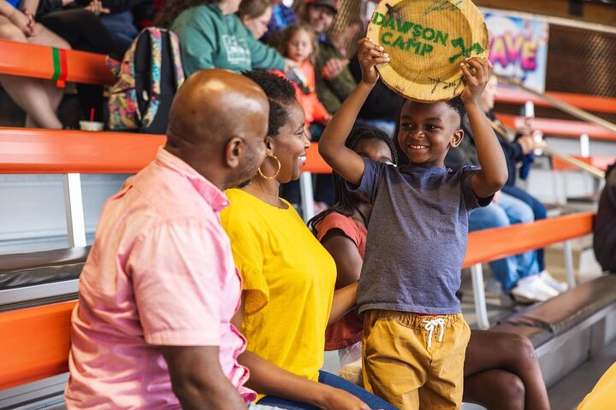 a young boy holding a ball in a crowd