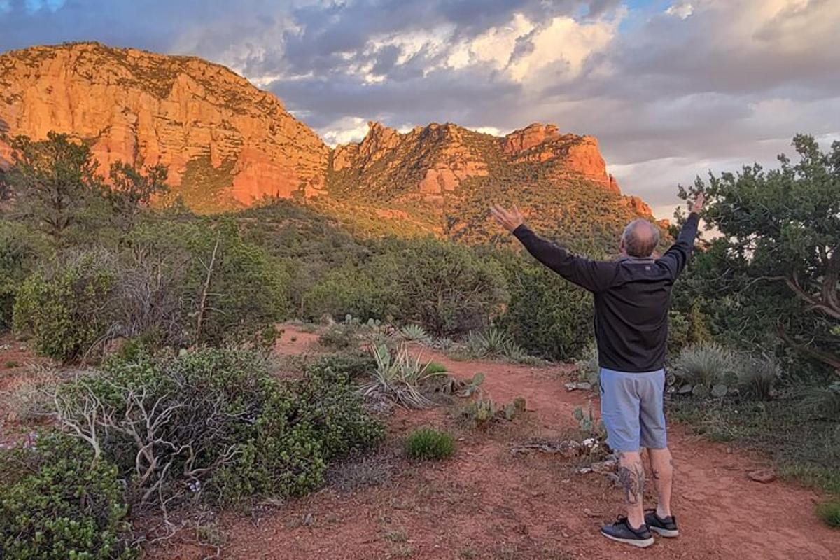 Un hombre parado en el desierto con los brazos en alto