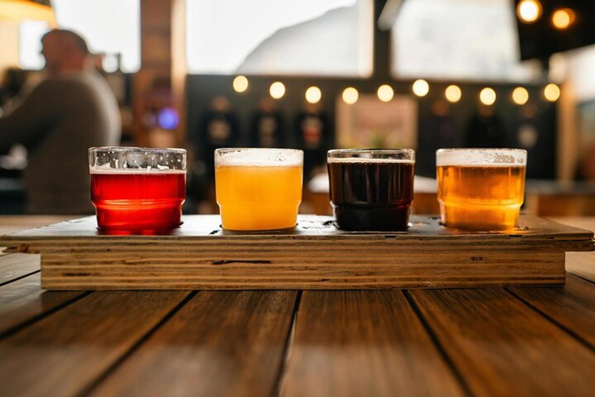 three glasses of beer on a wooden tray on a table