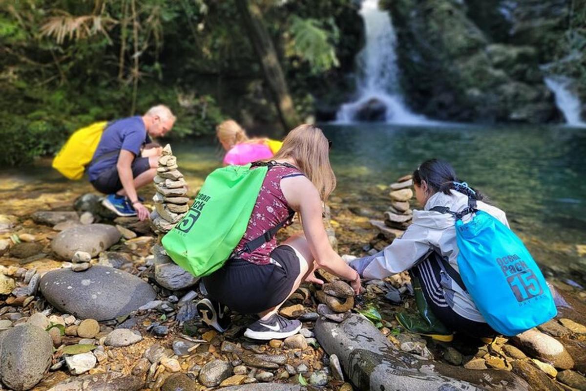 un gruppo di persone sedute sulle rocce vicino a una cascata