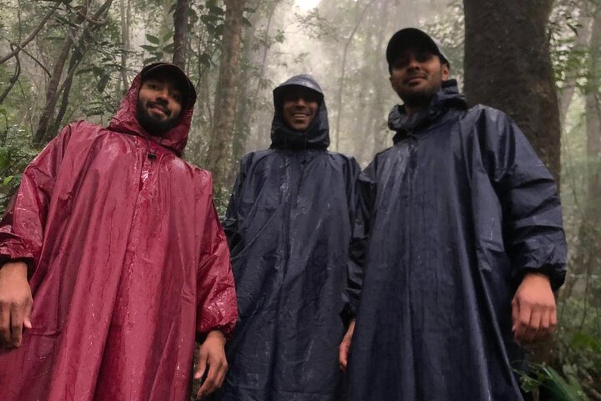 tre uomini in impermeabili in piedi in una foresta