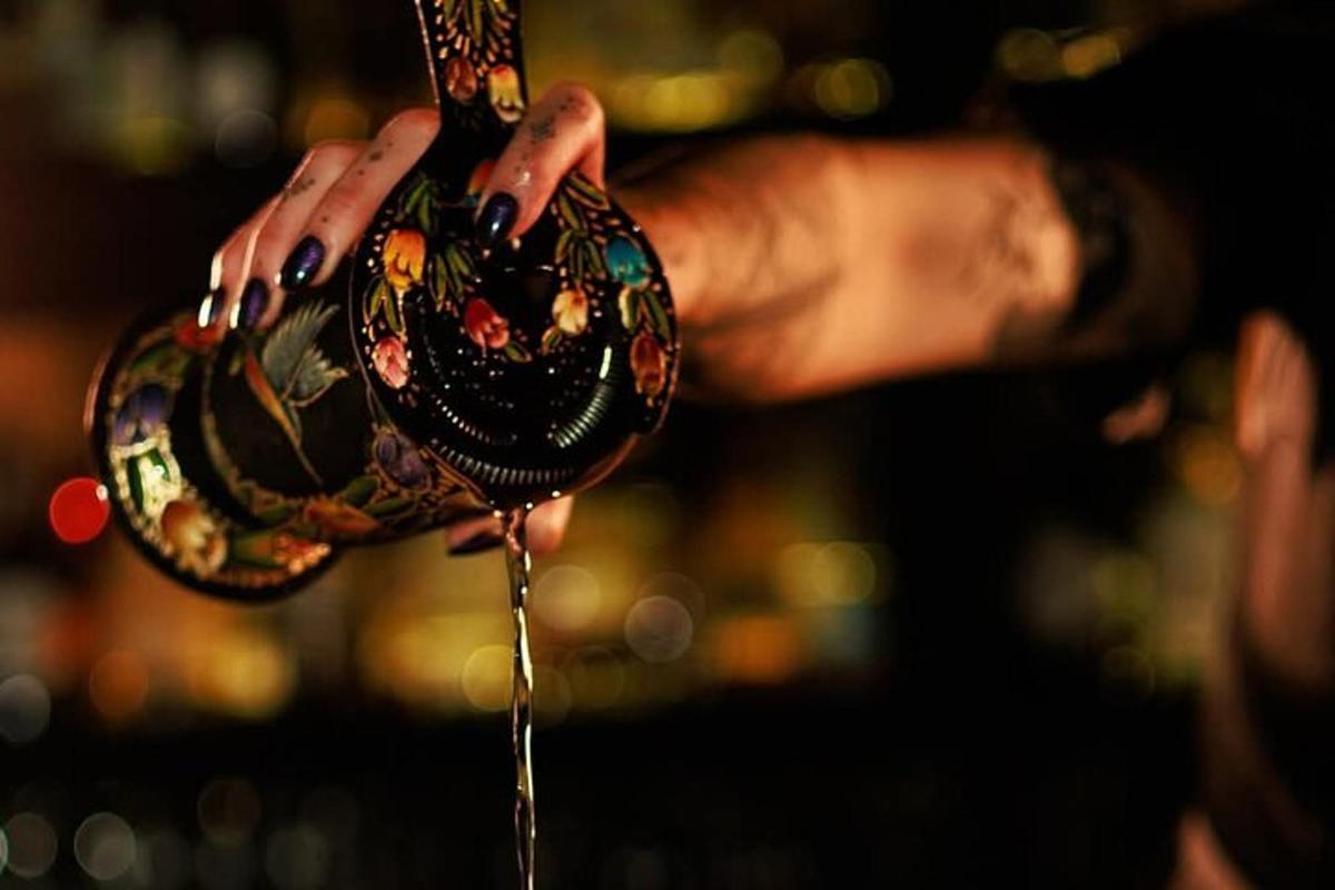 o persoană care ține un pahar de vin în mână