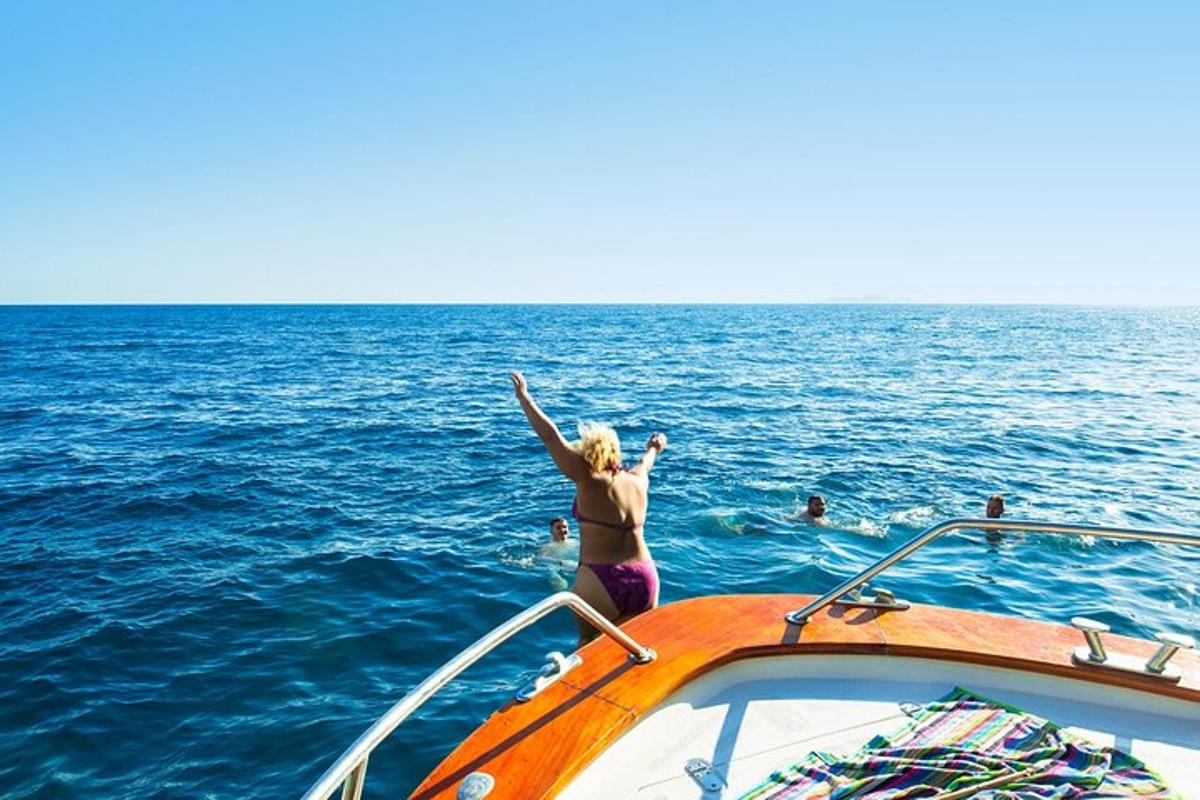 una dona dempeus a la part davantera d'un vaixell a l'oceà