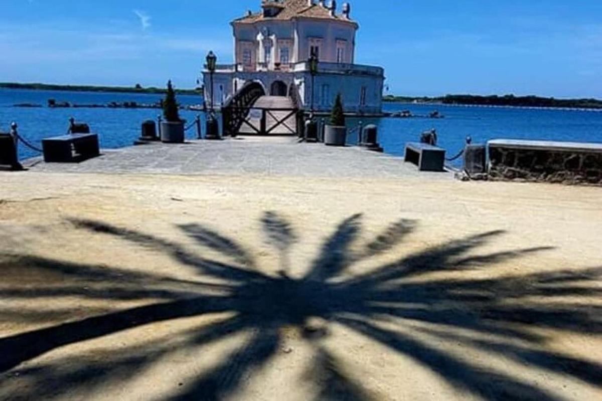 un'ombra di un edificio di fronte a uno specchio d'acqua