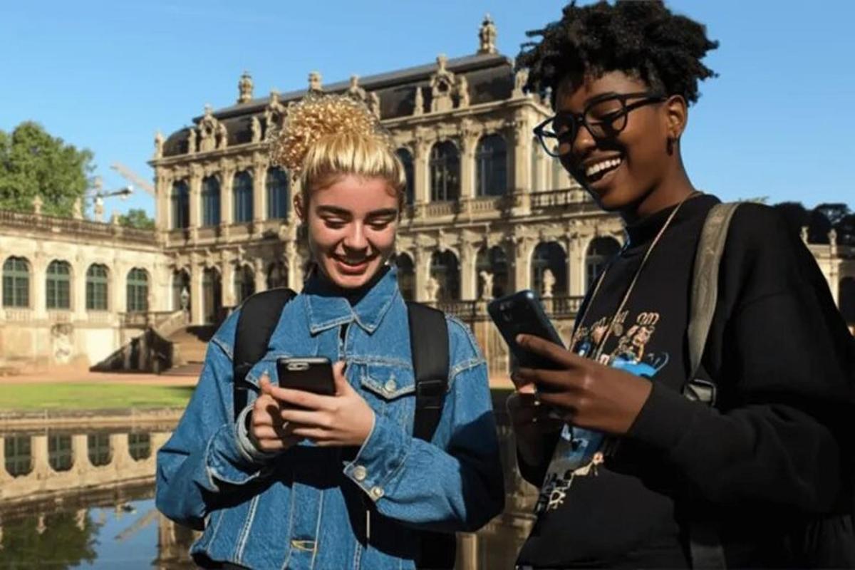 dvě ženy se smějí a dívají se do svých mobilních telefonů