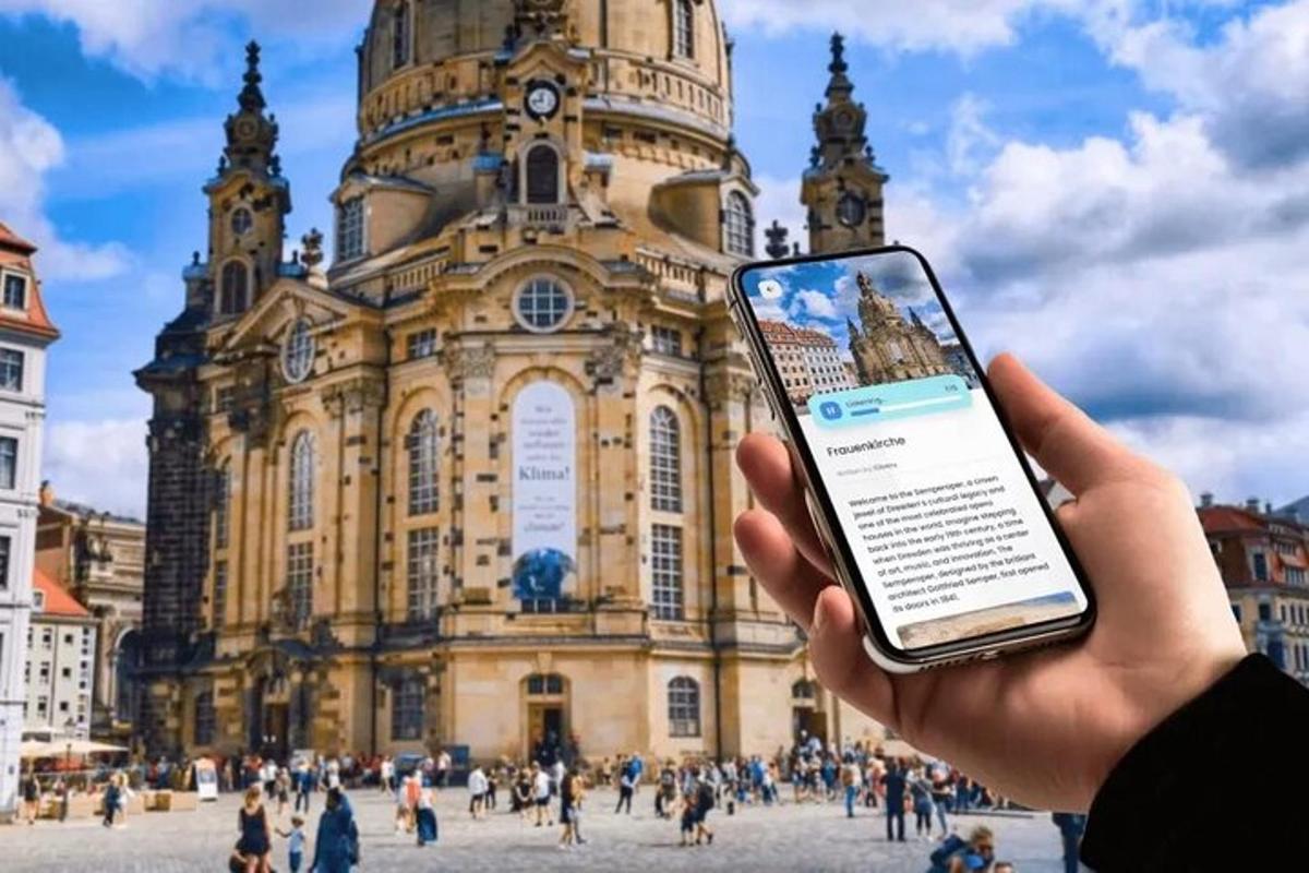 osoba držící mobilní telefon před budovou