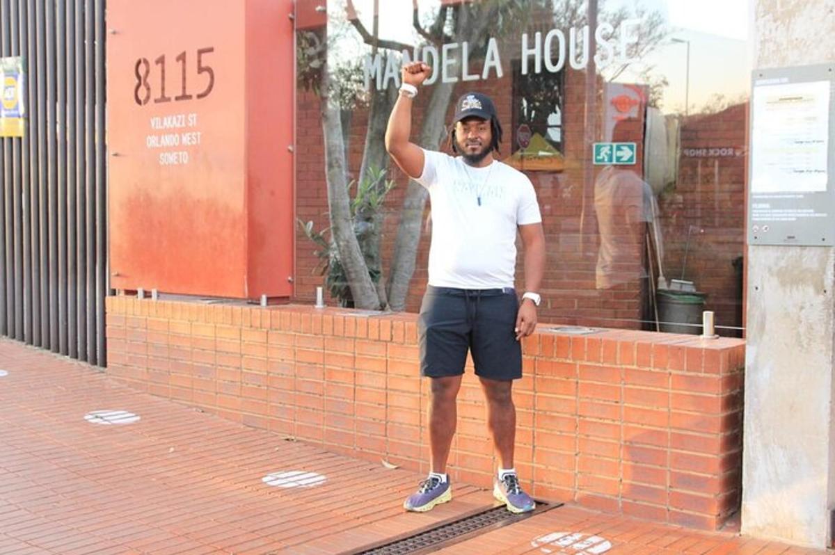 un uomo in piedi davanti a un edificio con in mano una racchetta da tennis